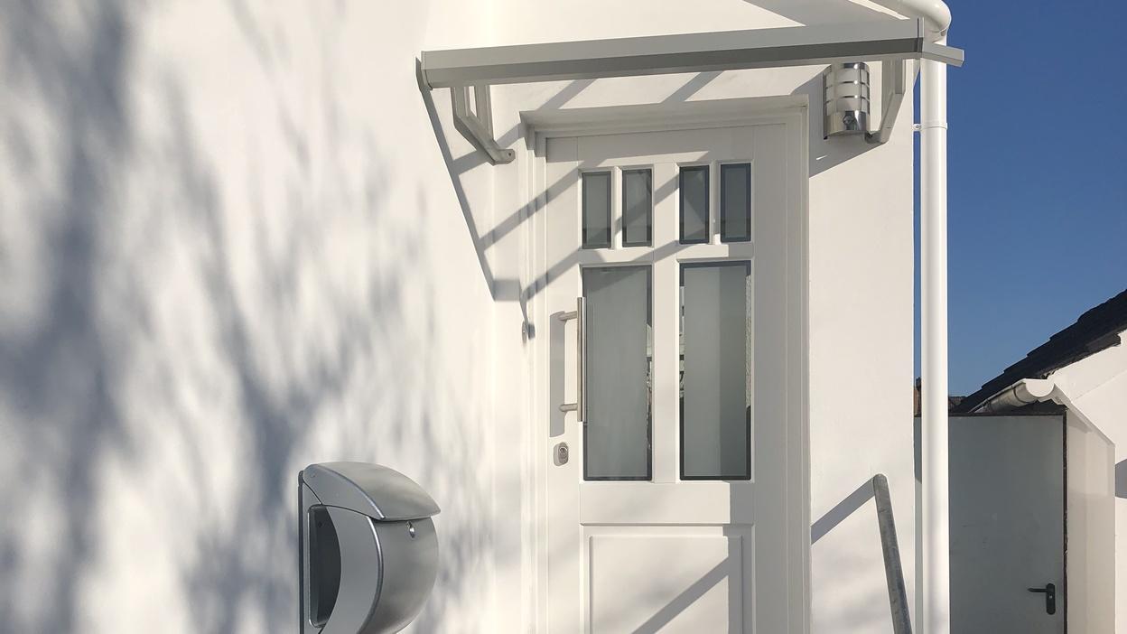 Hauseingang mit weißer Haustür Hauseingang über Treppe mit weißer Haustür